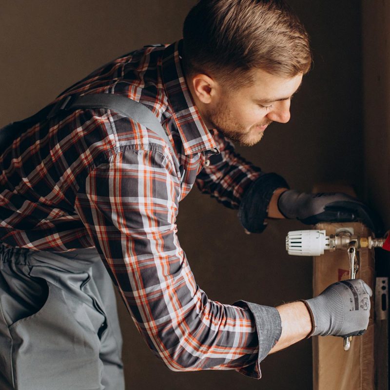 Service man adjusting house heating system